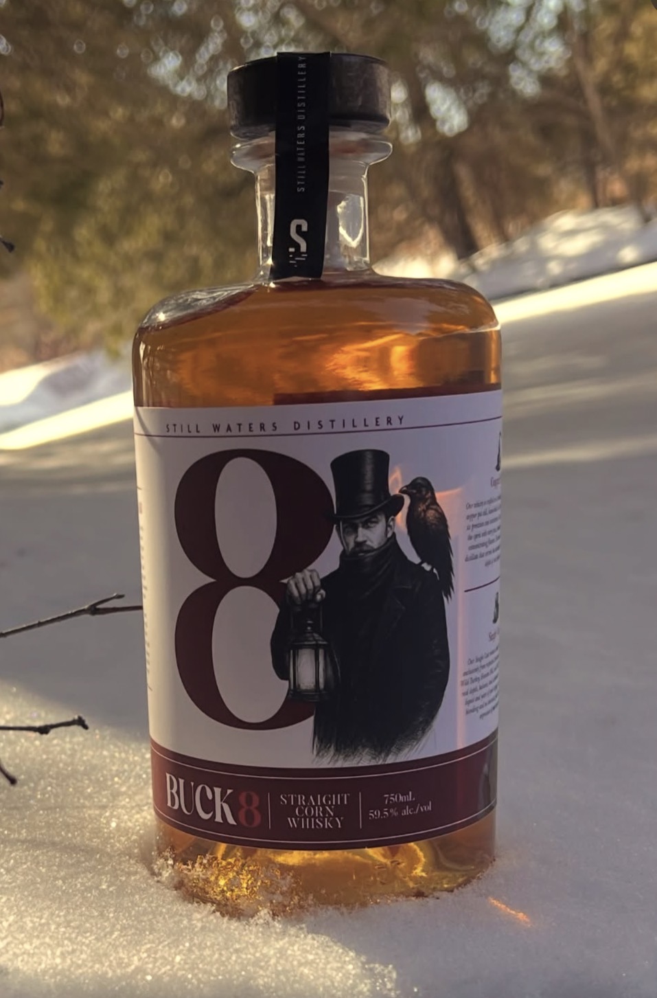 Bottle of Buck 8 Straight Corn Whisky photographed in the snow